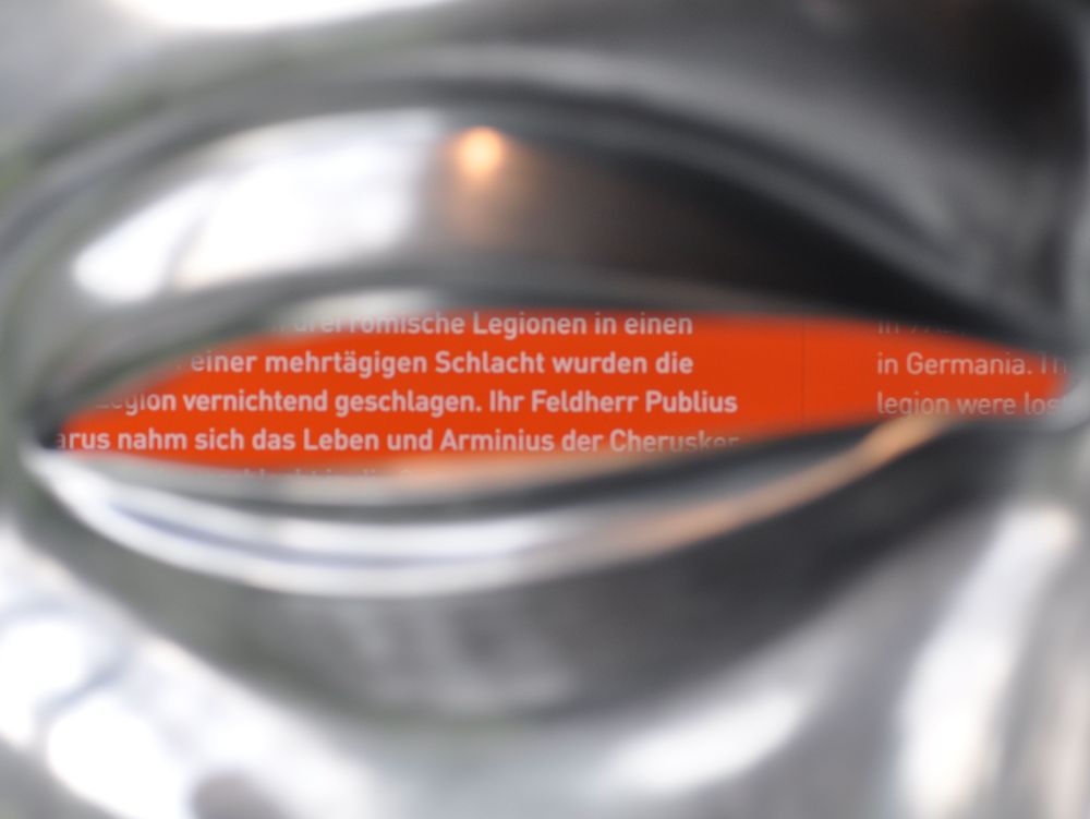 Detailaufnahme der Reitermaske, ein orangener Schriftzug verdeckt das Auge.
